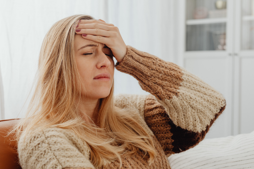 Vrouw met migraine en haar hand op haar voorhoofd